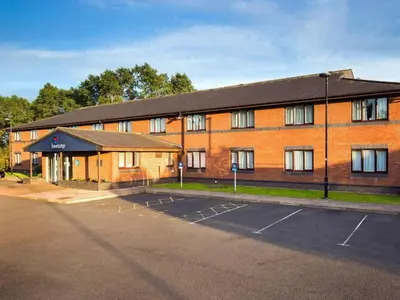 a large brick building with a parking lot in front of it at Travelodge Carlisle Todhills in Rockcliffe