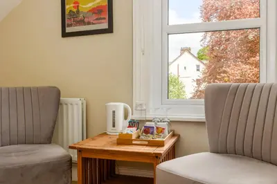 a room with two chairs and a table and a window at Woodside B & B in Keswick