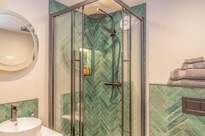 a shower with a glass door in a bathroom at Luxurious Barn within easy reach of South Lakes! in Boot