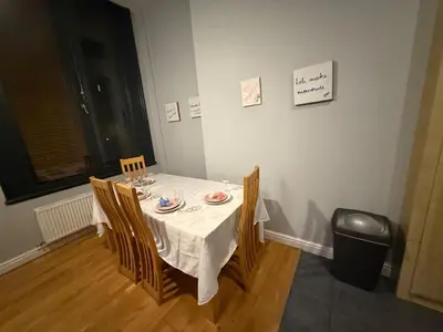 a dining room table with a white table cloth and chairs at Flat in the heart of Liverpool city centre in Moffat
