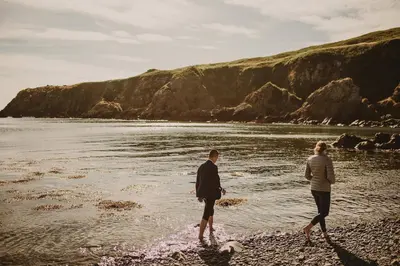 a man and a woman standing on a beach at Castle Penthouse on Estate by the Sea in Enoch