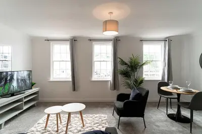 a living room with a tv and a table and chairs at Bright 1 Bed Harbour-side Apartment in Whitehaven in Whitehaven