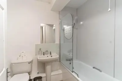a white bathroom with a toilet and a sink at Bright 1 Bed Harbour-side Apartment in Whitehaven in Whitehaven