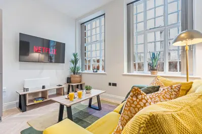 a living room with a couch and a table at Central Jewellery Quarter 1-Bedroom with Parking in Moffat