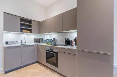 a kitchen with white cabinets and stainless steel appliances at Central Jewellery Quarter 1-Bedroom with Parking in Moffat