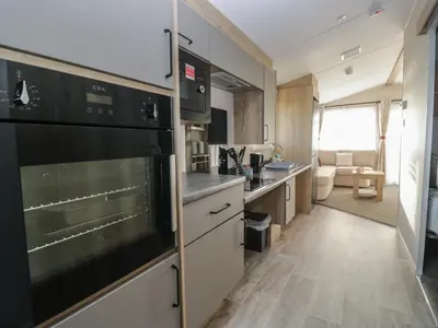a kitchen with a large oven and a living room at Guillemot in St Bees