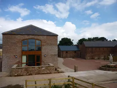 a brick building with a large window on it at Centurion, Irthington on Hadrians Wall in Irthington