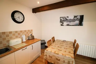 a kitchen with a table and a clock on the wall at Centurion, Irthington on Hadrians Wall in Irthington