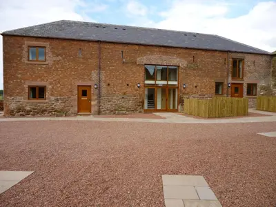 a brick building with a courtyard in front of it at Fortress, Irthington on Hadrians Wall in Irthington