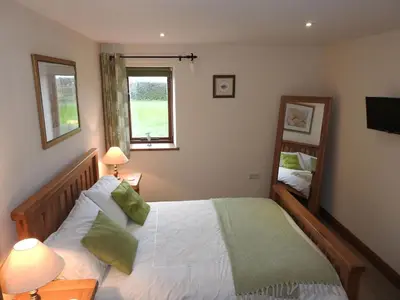 a bedroom with a large bed and a mirror at Fortress, Irthington on Hadrians Wall in Irthington