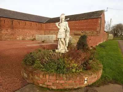 a statue of a woman in front of a brick building at Fortress, Irthington on Hadrians Wall in Irthington