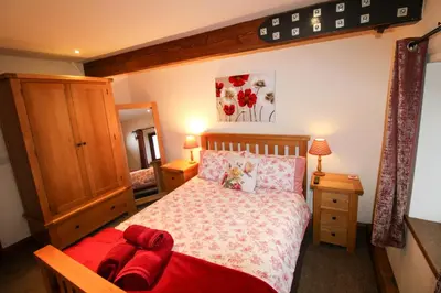 a bedroom with a large bed with a red blanket at Milecastle, Irthington on Hadrians Wall in Irthington