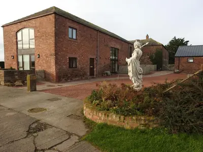 a statue of a woman in front of a brick building at Stanegate, Irthington on Hadrians Wall in Irthington