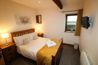 a bedroom with a bed and a window and a television at Turret, Irthington on Hadrians Wall in Irthington