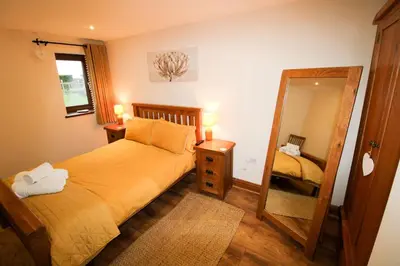 a small bedroom with a bed and a mirror at Vallum, Irthington on Hadrians Wall in Irthington