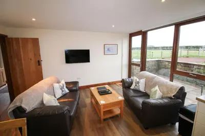 a living room with two leather chairs and a table at Vallum, Irthington on Hadrians Wall in Irthington