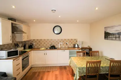 a kitchen with a table and a clock on the wall at Vallum, Irthington on Hadrians Wall in Irthington