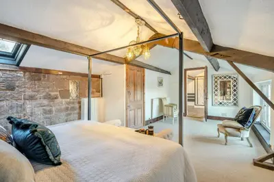 a bedroom with a large bed and a stone wall at 6 Bed in Low Moresby oc-l34667 in Distington