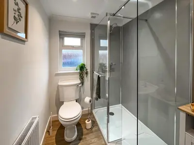 a bathroom with a toilet and a glass shower at Taigh-Beag - Uk50660 in Wigtown