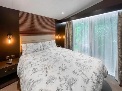 a bedroom with a bed and a large window at Blencathra View - Uk50085 in Penruddock