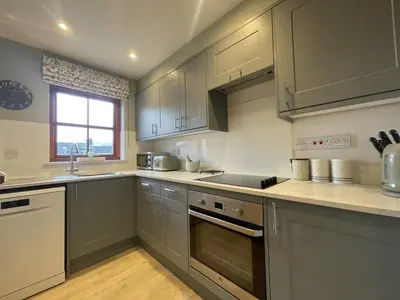 a kitchen with gray cabinets and a sink and a stove at Catbells in Keswick