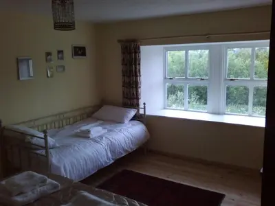 a bedroom with a bed and a window at Cargenbank Farmhouse in Lochfoot