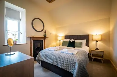 a bedroom with a bed with a mirror and a fireplace at The Old Vicarage Irton in Parton