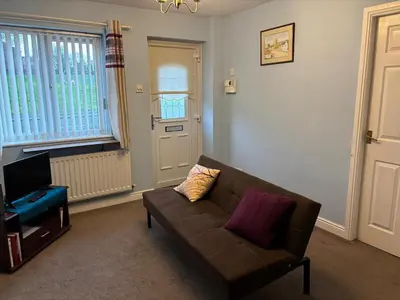 a living room with a couch and a television at 1-Bed Suburban Carlisle Terraced Home with Parking in Carlisle
