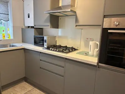 a kitchen with white cabinets and a stove top oven at 1-Bed Suburban Carlisle Terraced Home with Parking in Carlisle