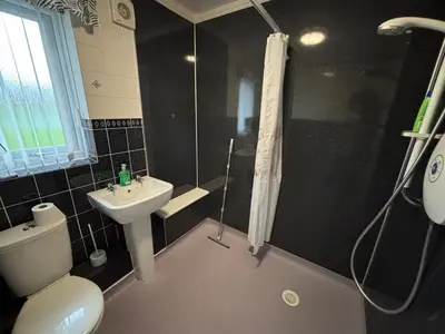 a bathroom with a toilet and a sink and a shower at 1-Bed Suburban Carlisle Terraced Home with Parking in Carlisle