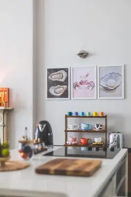 a kitchen with a counter top with paintings on the wall at Luxury MArylebone Village family home in Moffat