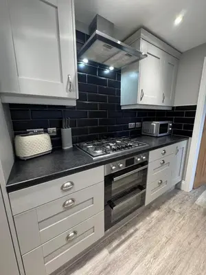 a kitchen with white cabinets and a stove top oven at Granville Road, near Hospital, sleeps 5 in Carlisle