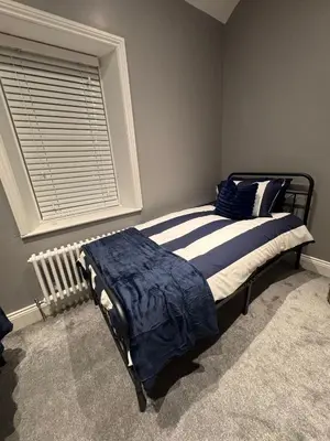 a bedroom with a bed and a window with a radiator at Granville Road, near Hospital, sleeps 5 in Carlisle