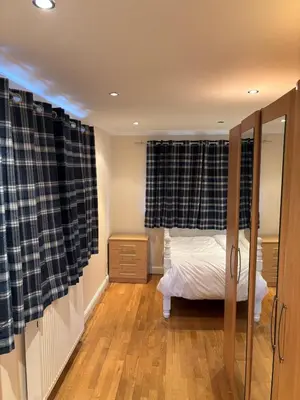 a bedroom with a bed and a window with curtains at Peace Haven Hendon London NW4 in Moffat