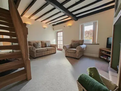 a living room with two couches and a staircase at 4 Bed in Ireby oc-p34997 in Ireby