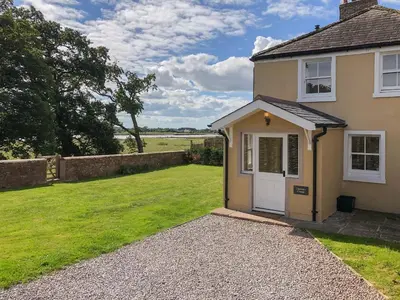 a house with a white door and a grass yard at Solway Marsh View - Uk1553 in Rockcliffe