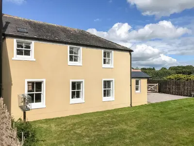 a yellow house with white windows and a yard at Solway Marsh View - Uk1553 in Rockcliffe