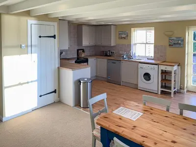 a kitchen with a table and a refrigerator and a sink at Solway Marsh View - Uk1553 in Rockcliffe