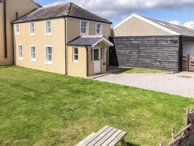 a house with a grassy yard next to a building at Solway Marsh View - Uk1553 in Rockcliffe
