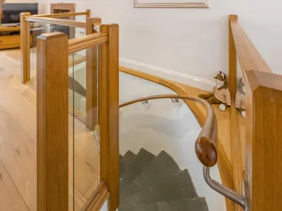 a glass staircase in a house with a wooden railing at Mary's Cottage in Keswick