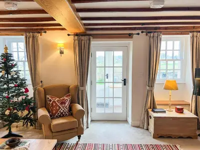 a living room with a christmas tree and a chair at Crofthead in Hesket Newmarket