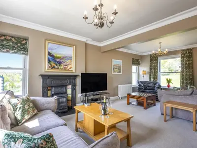 a living room with a fireplace and a tv at Mount Pleasant in Threlkeld