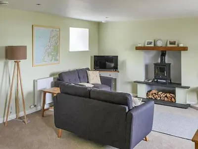 a living room with a couch and a fireplace at Dairy Cottage in Girvan