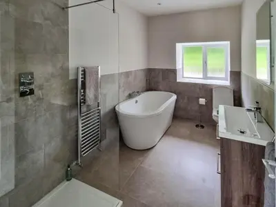 a bathroom with a tub and a toilet and a sink at Lady Farm in Girvan