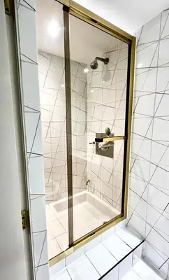 a shower with a glass door in a bathroom at Mayfair Piccadilly Apartemnt - 3 in Moffat