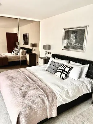 a bedroom with a large bed and a mirror at Mayfair Piccadilly Apartemnt - 3 in Moffat
