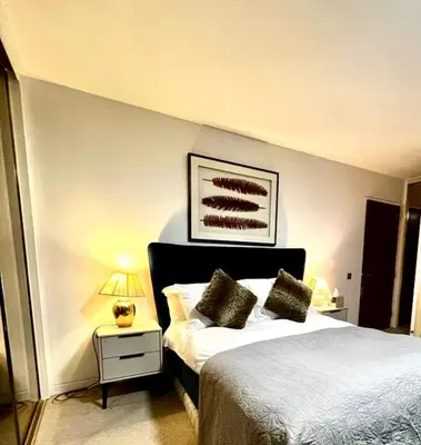 a bedroom with a bed and a lamp on a table at Mayfair Piccadilly Apartemnt - 3 in Moffat