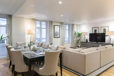 a living room with a couch and a table with chairs at Luxury 2BR Park Lane Apartment Mayfair Sleeps 6 PL15B in Moffat