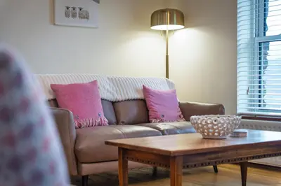 a living room with a couch and a coffee table at Wreay Lodge - Fellside Home with Lake Views in Watermillock