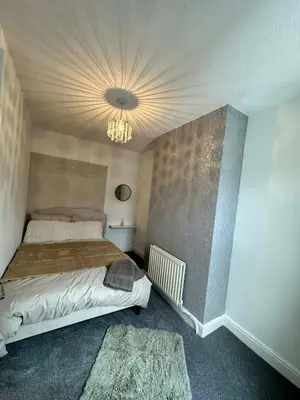 a bedroom with a bed and a chandelier at Comfortable Stay with Free Parking in Cleator